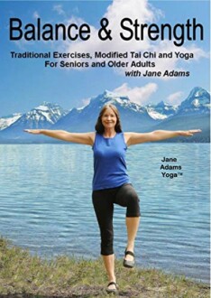 Woman practicing yoga outdoors with mountains in background.