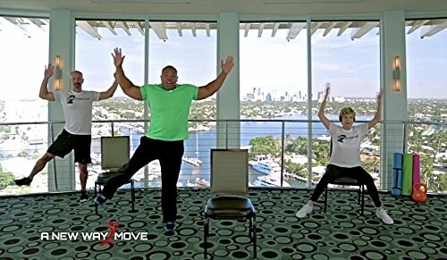 Group exercise class with three people and chairs in a room with large windows.